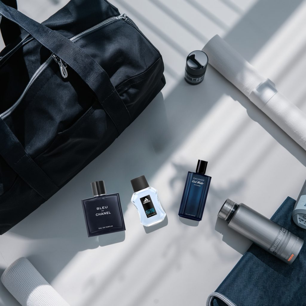 Flat lay of best gym bag colognes for men 2026 including Nautica Voyage, Bleu de Chanel EDT and Acqua di Gio